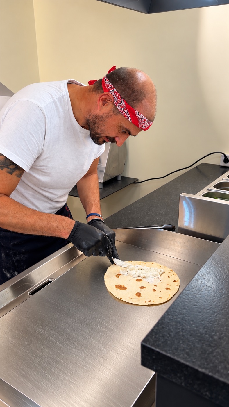 Pit bestreicht eine frisch gebackene Piadina mit Frischkäse