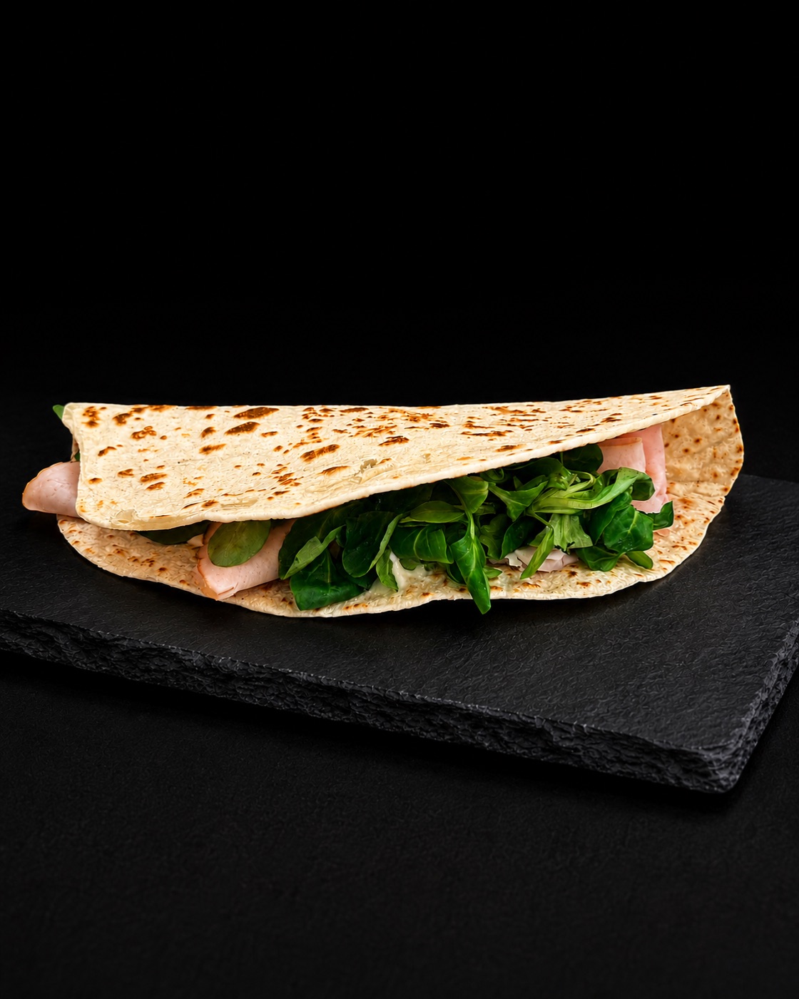 Piadina mit Schinken und Feldsalat auf Schieferplatte